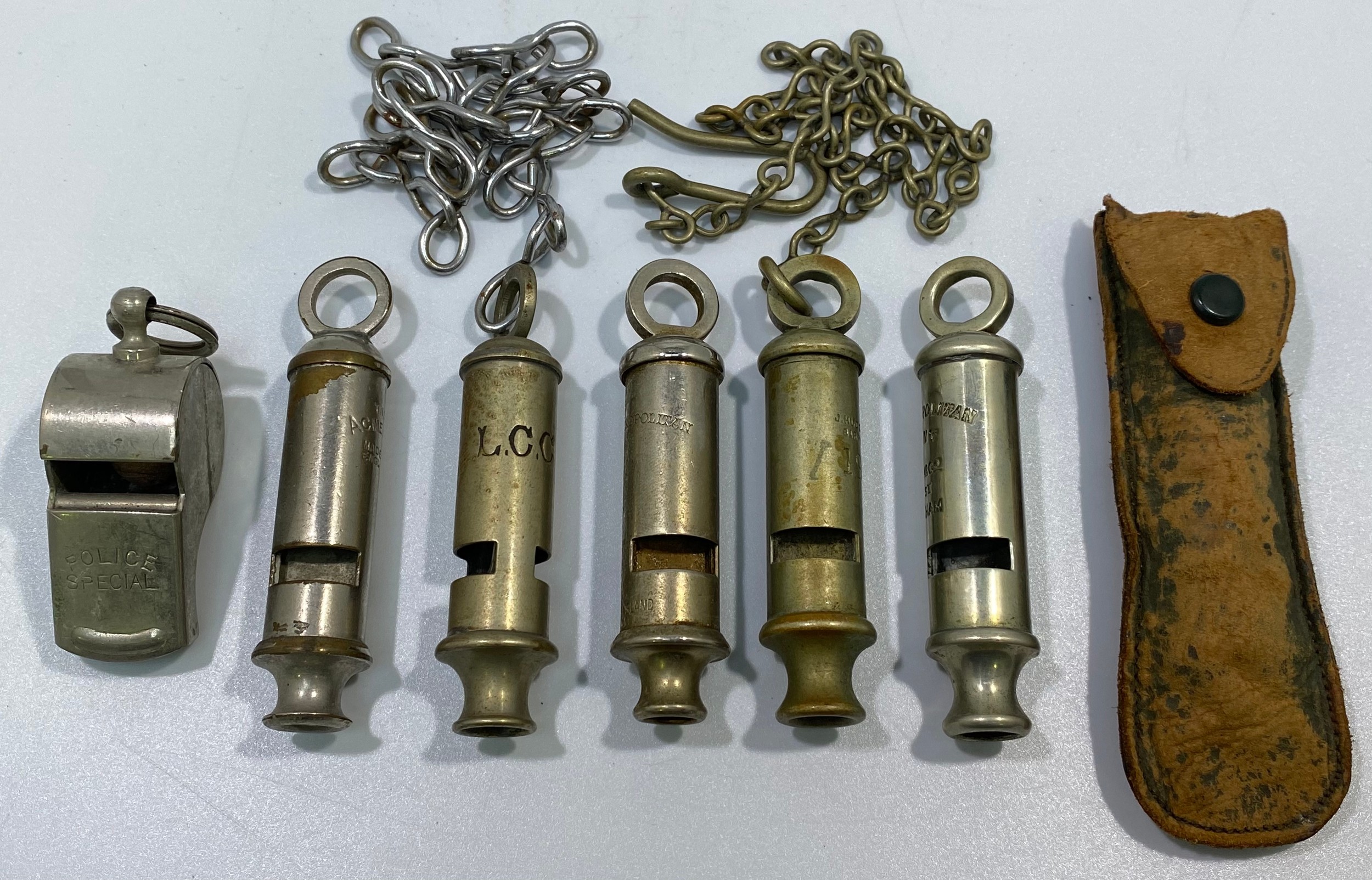 Six various whistles including LCC, a 1915 dated example with chain and button hook, ACME