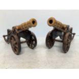 A pair of brass cannons raised on cast iron bases, cannons 30cm, overall 45cm