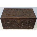 An Oriental camphor wood blanket box, of rectangular form, profusely carved with scenes of