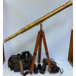 A floor standing brass telescope with wooden tripod stand, together with a quantity of camera