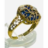 A 9ct yellow gold dress ring, set with a cushion shaped lapis lazuli stone, with gold filigree