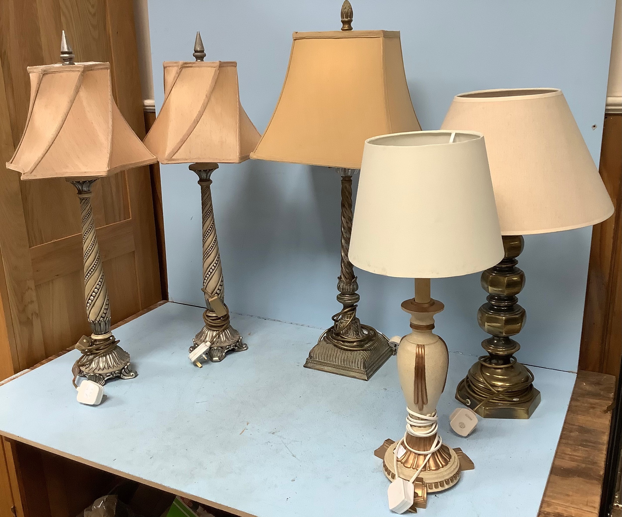 A pair of tall table lamps with silvered twisted and beaded bases and shaped shades, together with a