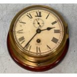 A brass cased Smith Astral bulkhead clock with white enamel dial and black Roman numerals and