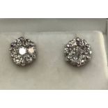 A pair of 14ct white gold and diamond cluster stud earrings, each set with seven round brilliant cut