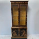 A modern Japanned cabinet with bevelled glass doors and sides enclosing three glass shelves, above a