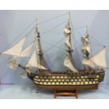 A large hand built model of HMS Victory fully rigged with Nelson standing on the bow, raised on