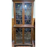 An Edwardian tall two-section bookcase, both sections with a pair of astragal glazed doors and