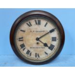 An early 20th century circular wall clock housed in a walnut frame, white painted dial with black