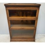 A Globe Wernicke style oak stacking bookcase with three graduated sections, ‘up and over’ glass