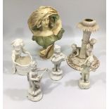 Three white German porcelain musical putti on scrolled bases, with an accordion, flute and mandolin,