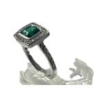 A 9ct white gold dress ring, set with a cushion cut green faceted stone to the centre, with small