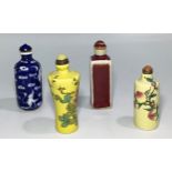 Four various Chinese snuff bottles including a yellow example with flowers, a blue and white example