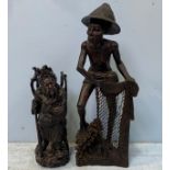 A South East Asian carved hardwood figure of a fisherman drawing his nets, 80cm high, and a