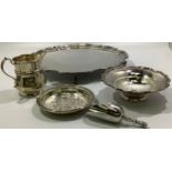 A silver cream jug together with a silver pin dish with shaped rim, a silver pin dish with floral