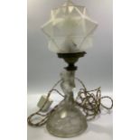 An Art Deco lamp with a clear glass nude female kneeling on a naturalistic circular base, holding