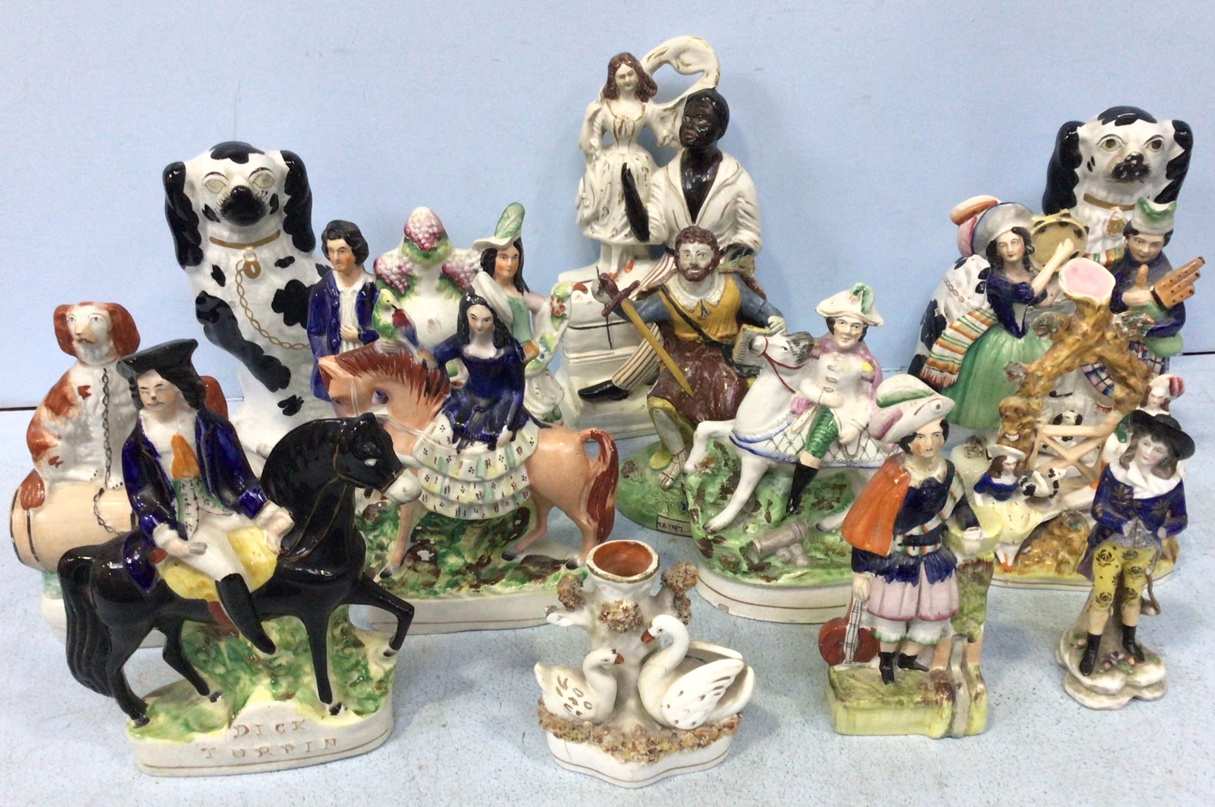 A collection of thirteen various 19th and 20th century Staffordshire pottery figural groups,