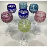 A harlequin set of seven St Louis overlay coloured stemmed wine hock glasses in green, blue and