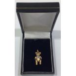 A 9ct gold articulated bear charm, with ruby eyes and small diamonds set to waistcoat, 21mm tall,