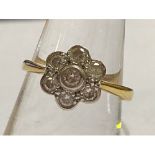 An 18ct yellow gold cluster ring, with seven round brilliant cut diamonds set in a daisy design,
