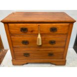 An Edwardian stained walnut chest of three drawers with art nouveau period handles, raised on