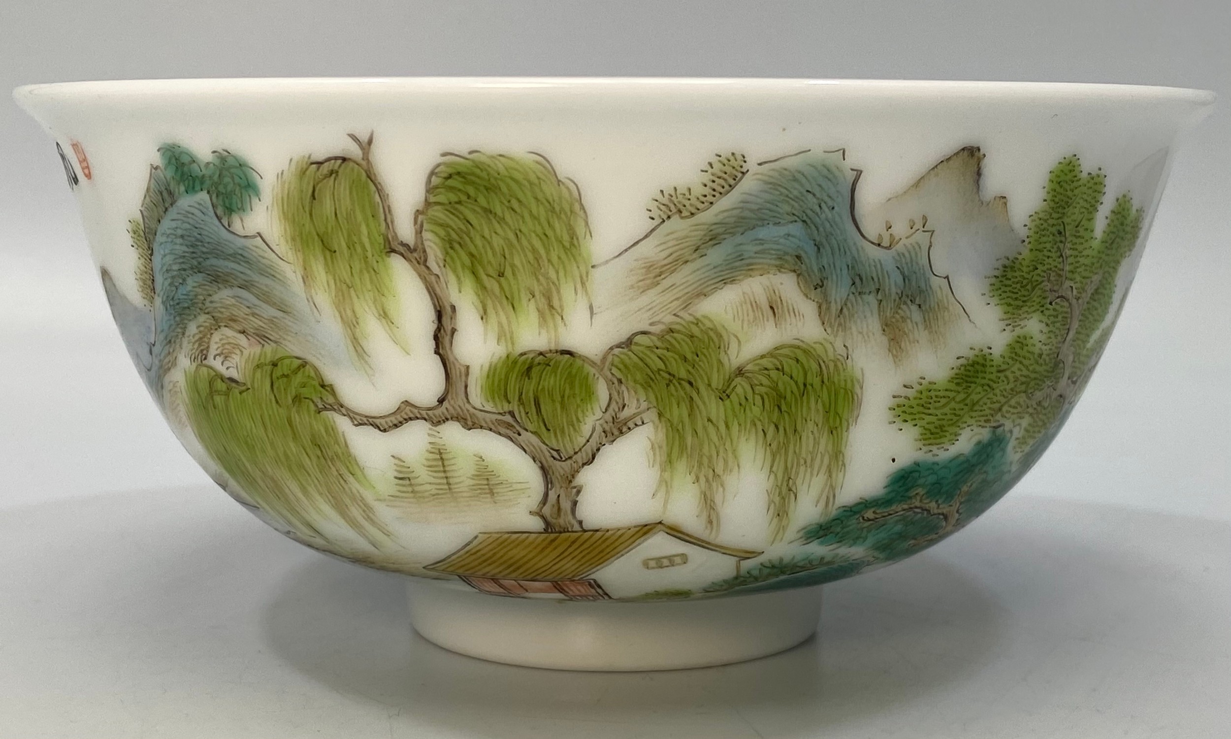 A Chinese porcelain bowl hand painted with a scene of a figure of a man on a raft with houses,