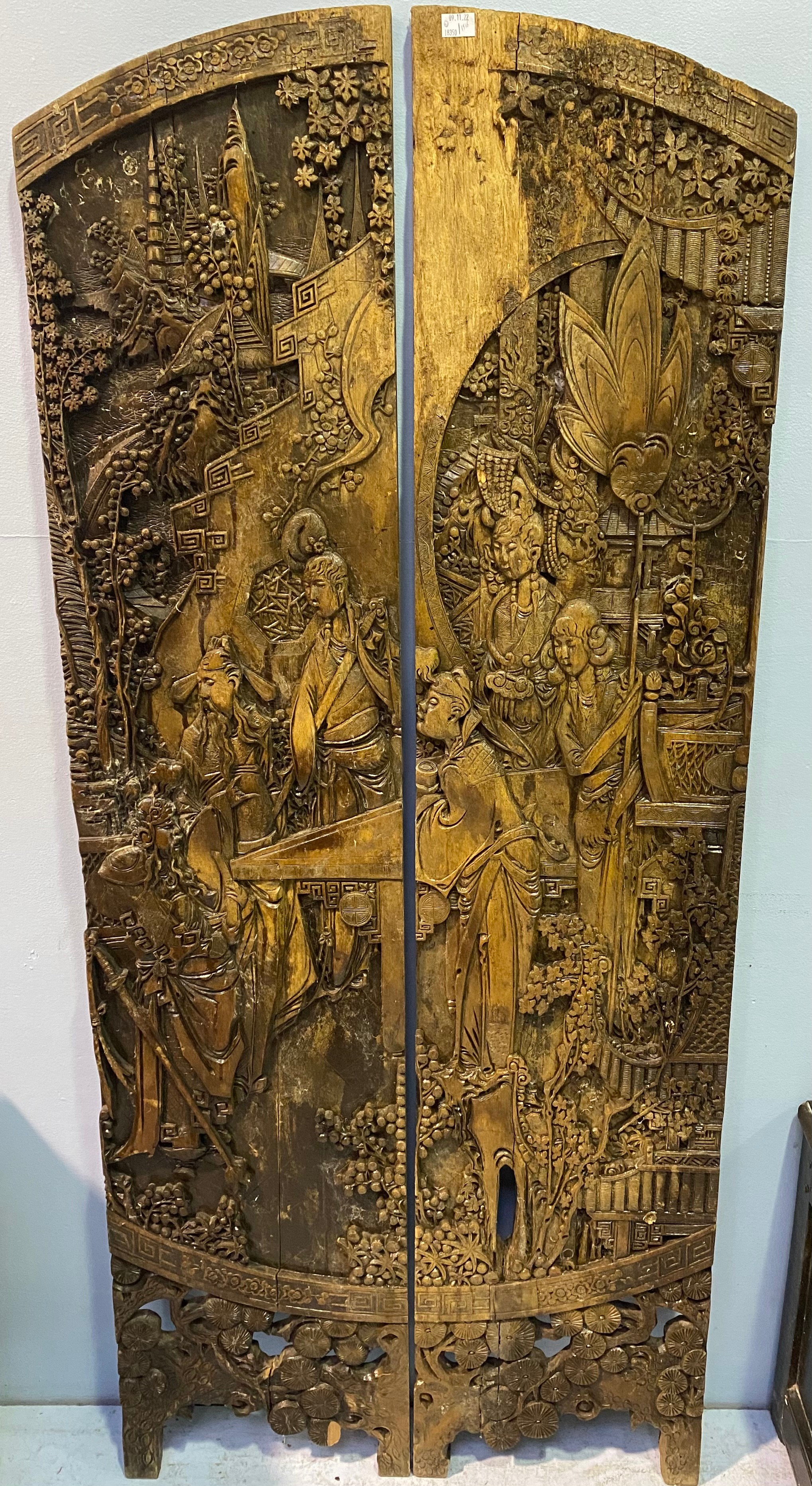 A pair of carved Chinese hardwood panels, formerly from a dressing screen, carved with figures