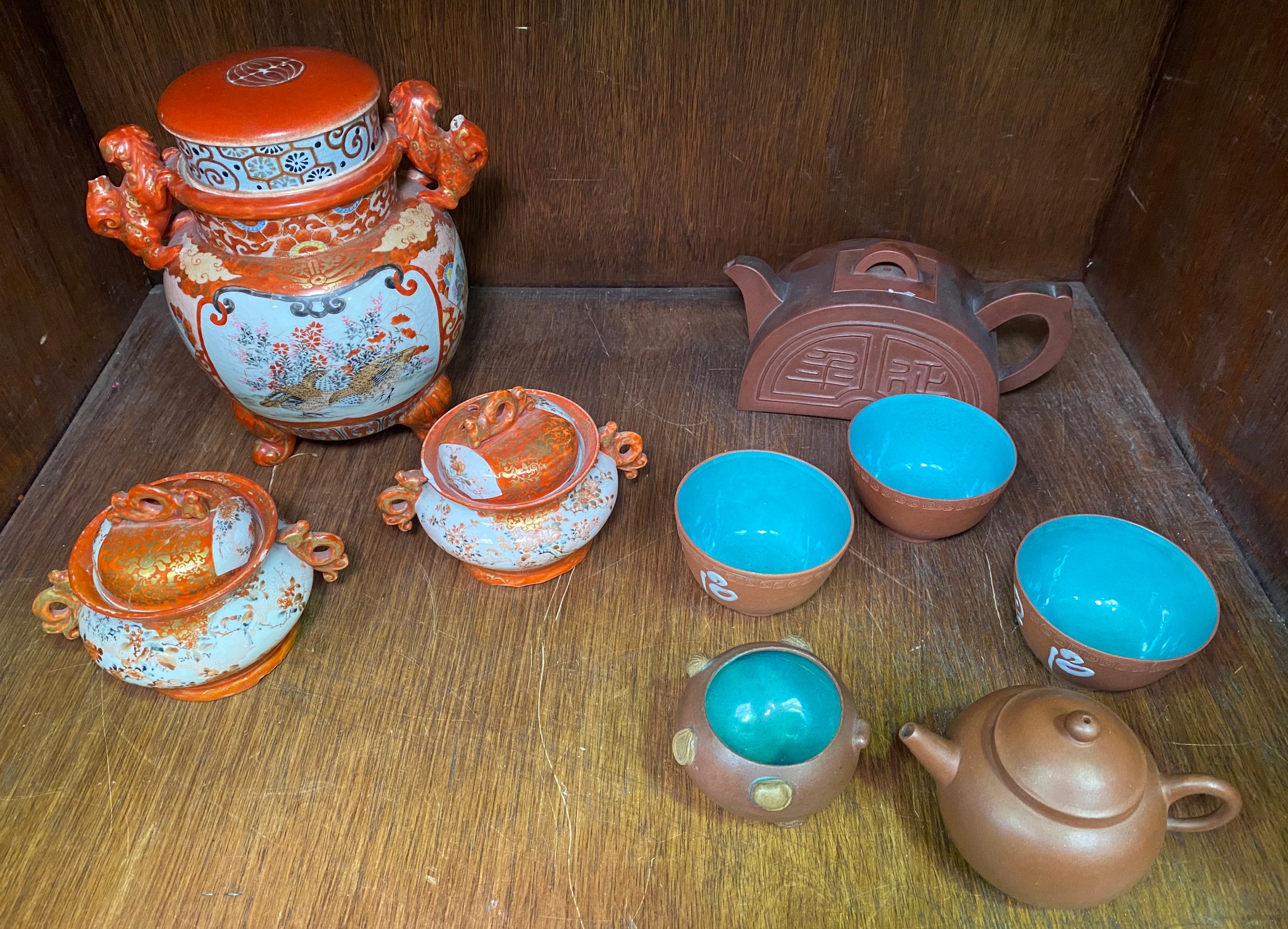 A Chinese coral ground porcelain vase and cover with fo dog handles (both with chipped tails), the