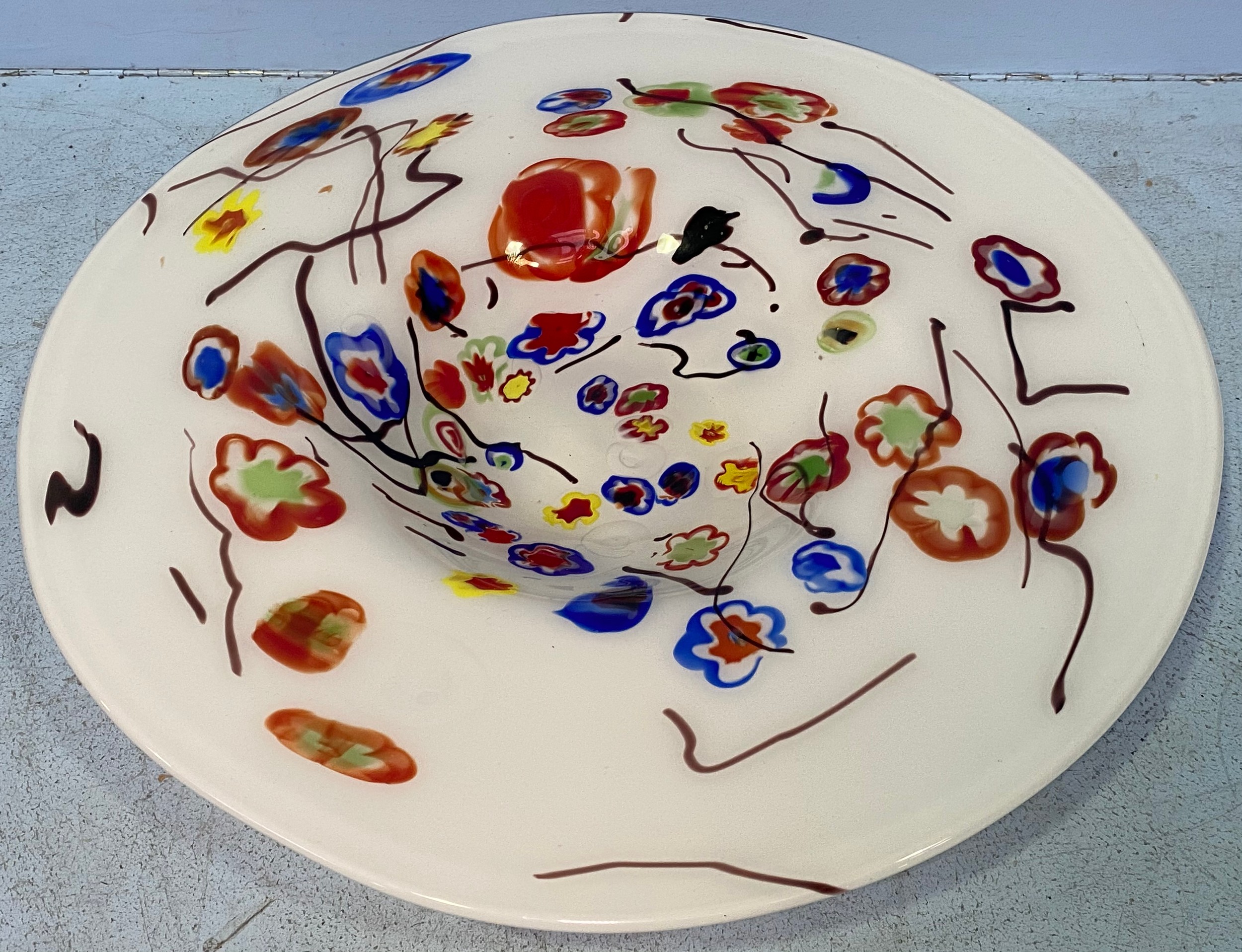 A large white opaque glass charger, decorated with multicoloured flowers, 47cm diameter