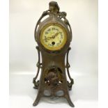 A Continental Art Nouveau painted spelter mantel clock, cast with floral whiplash and female mask,