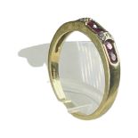 An 18ct yellow gold ring, channel set with six round rubies, and four small round diamonds, ring