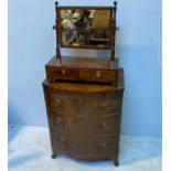 A walnut bow-front chest of three graduated drawers with brass handles and brushing slide, raised on