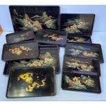 Eleven various Chinese hand painted black lacquered trays depicting scenes of dragons and