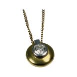 An 18ct white and yellow gold pendant, set with a round brilliant cut diamond to the centre,