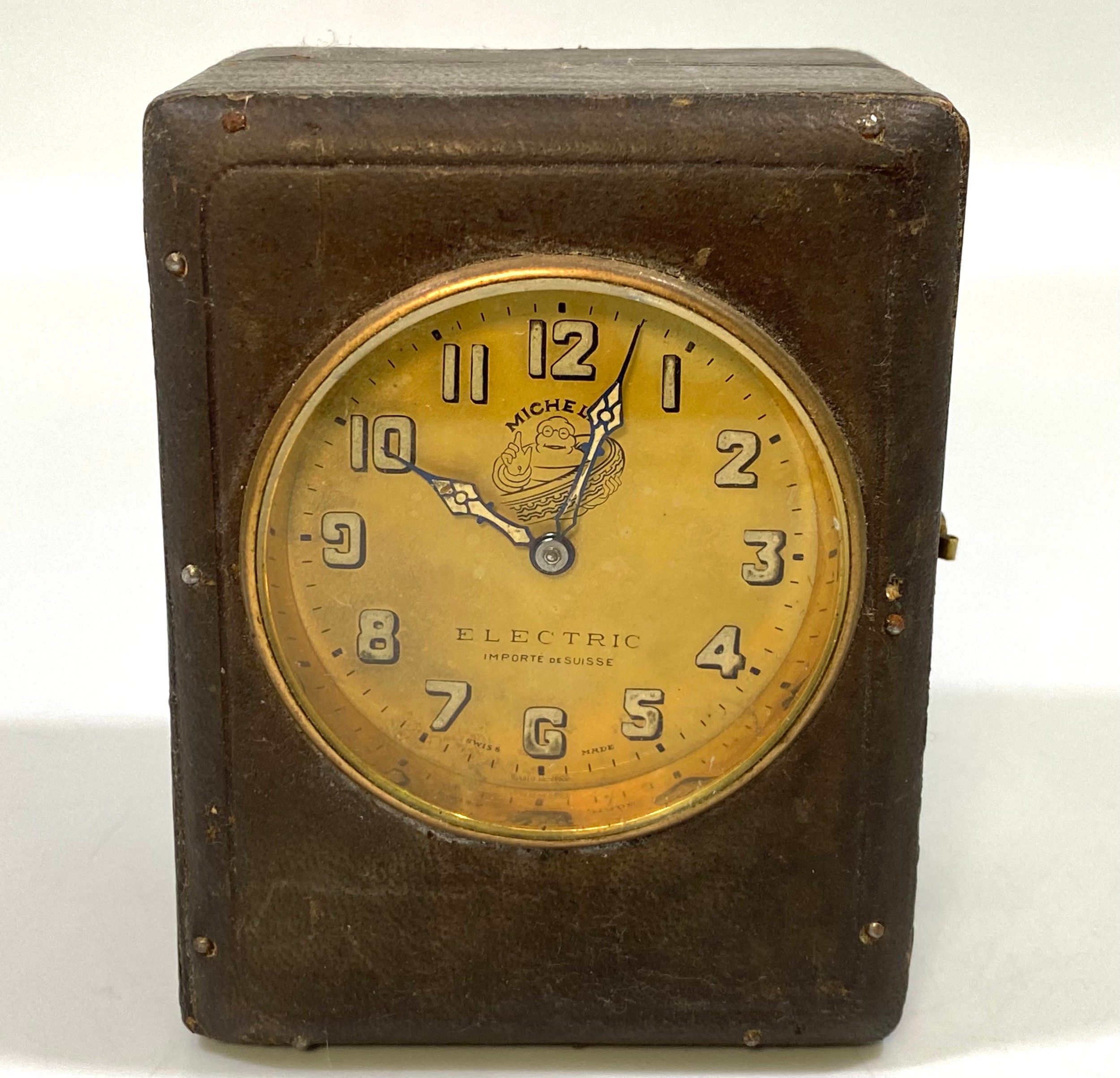 A 1920’s Michelin Electric travel clock, the brass dial with Arabic numerals denoting hours,