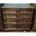 A 17th century oak chest of four long, graduated drawers with panelled fronts, brass drop pulls