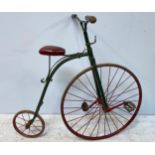 A child's Penny Farthing bicycle, painted in green with burgundy saddle, wooden handles, rear axle