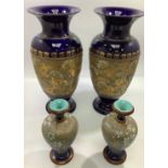 Two pairs of Royal Doulton stoneware vases with gilt decoration to dark blue ground, largest pair