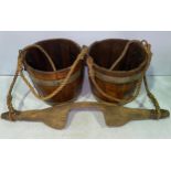 A wooden yoke with a pair of metal bound coopered buckets with twin handles and ropes