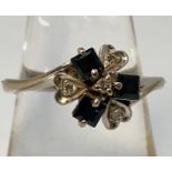 A 14ct white gold cluster ring, the top set with three square faceted sapphire coloured stones and