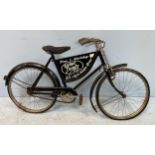 A vintage Raleigh bike painted in black with central advertisement panel ‘Shop & Workshop Carol