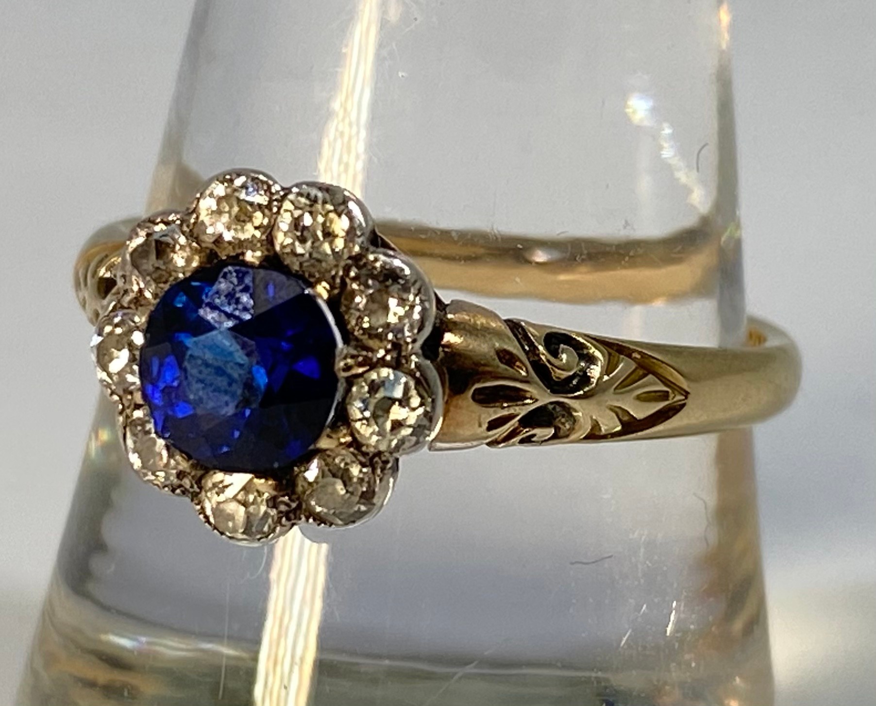 An 18ct gold ring, centrally claw set with a round, faceted sapphire coloured stone (loose in mount)