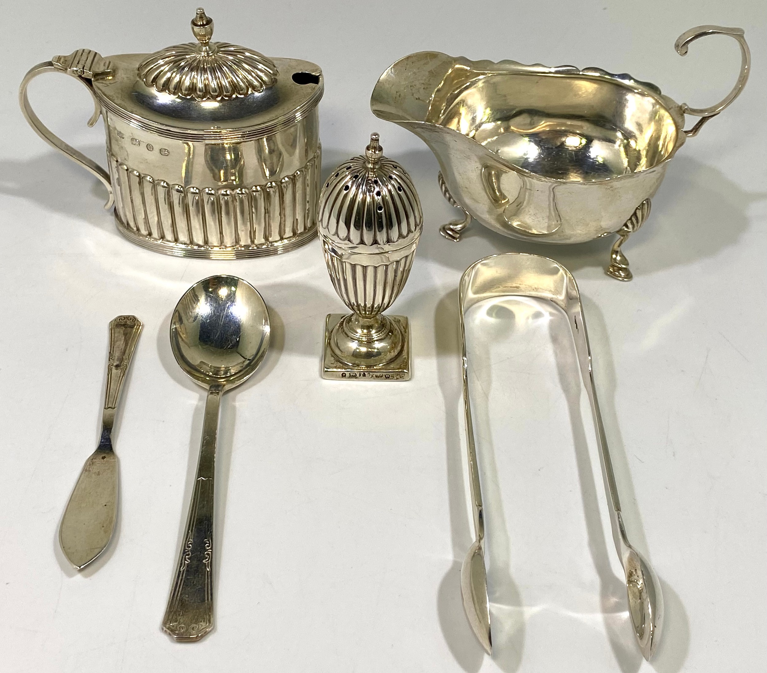 A silver mustard pot and cover with blue glass liner, together with a silver cream jug with