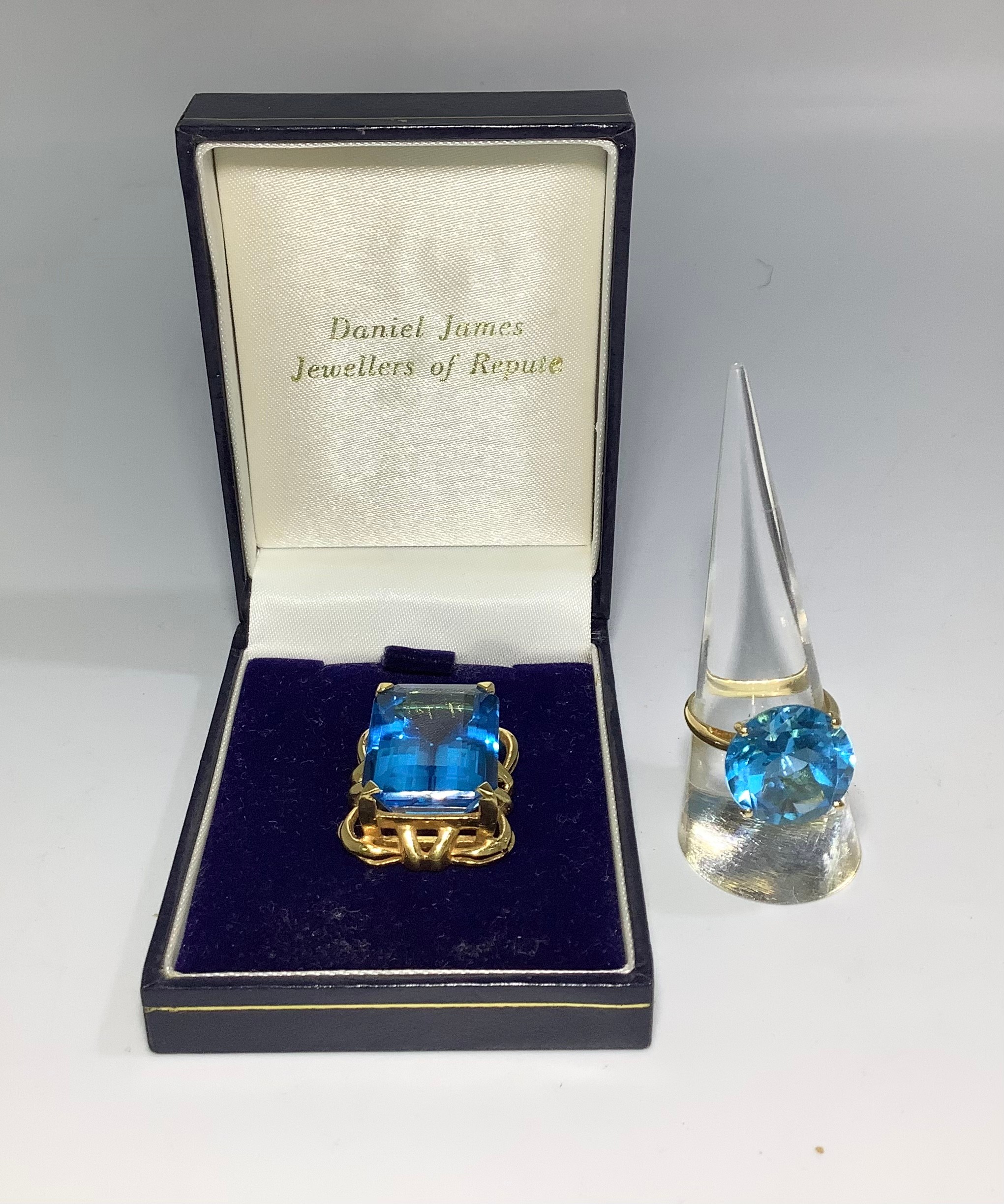 An 18ct gold ring, centrally four-claw set with a large round faceted blue topaz, together with a