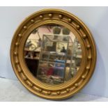 A regency style gilt-painted circular wall mirror with ball finials, 62cm wide