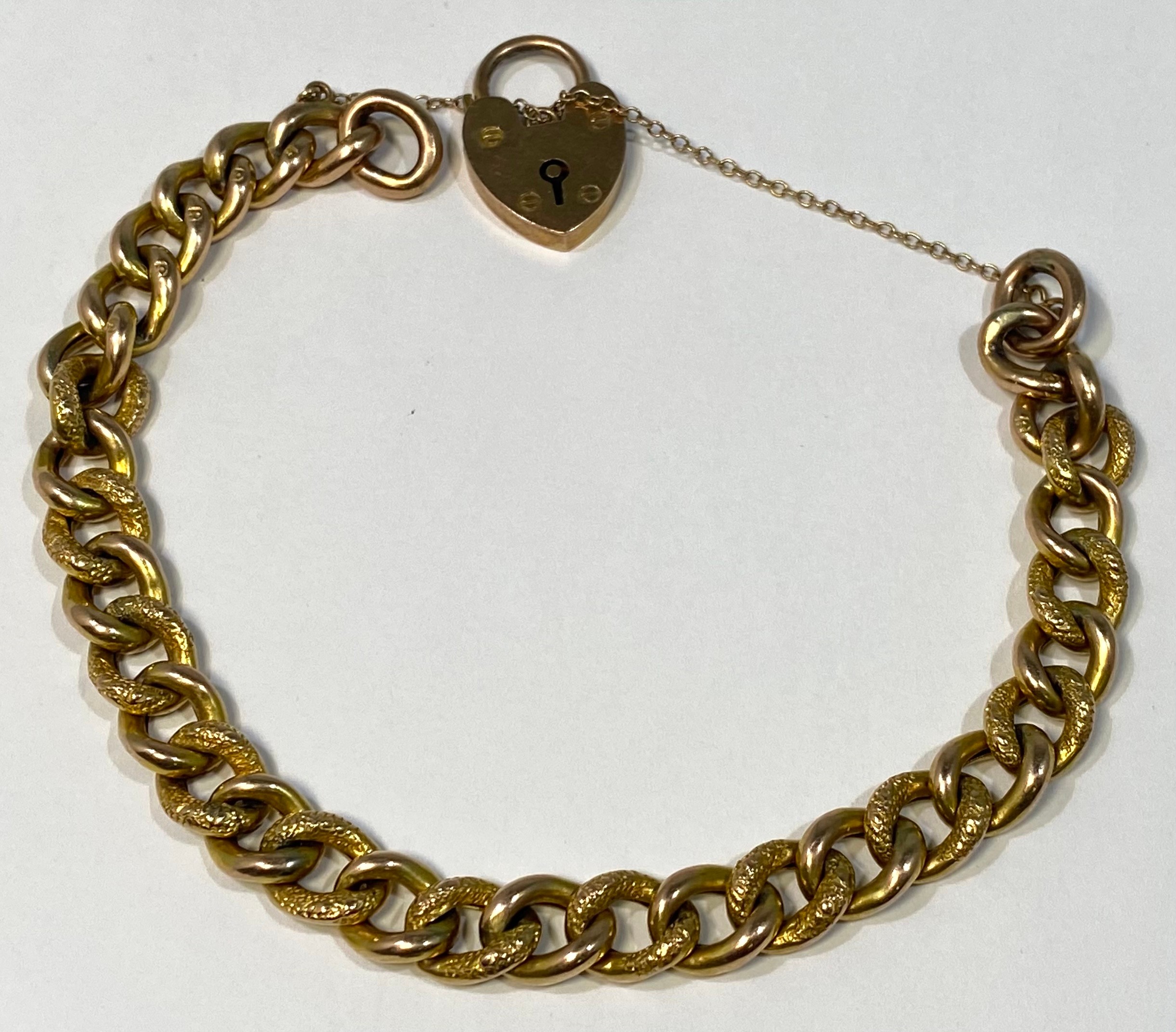 A 9ct gold curb link bracelet with heart-shaped padlock and safety chain, gross weight approximately