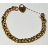 A 9ct gold curb link bracelet with heart-shaped padlock and safety chain, gross weight approximately