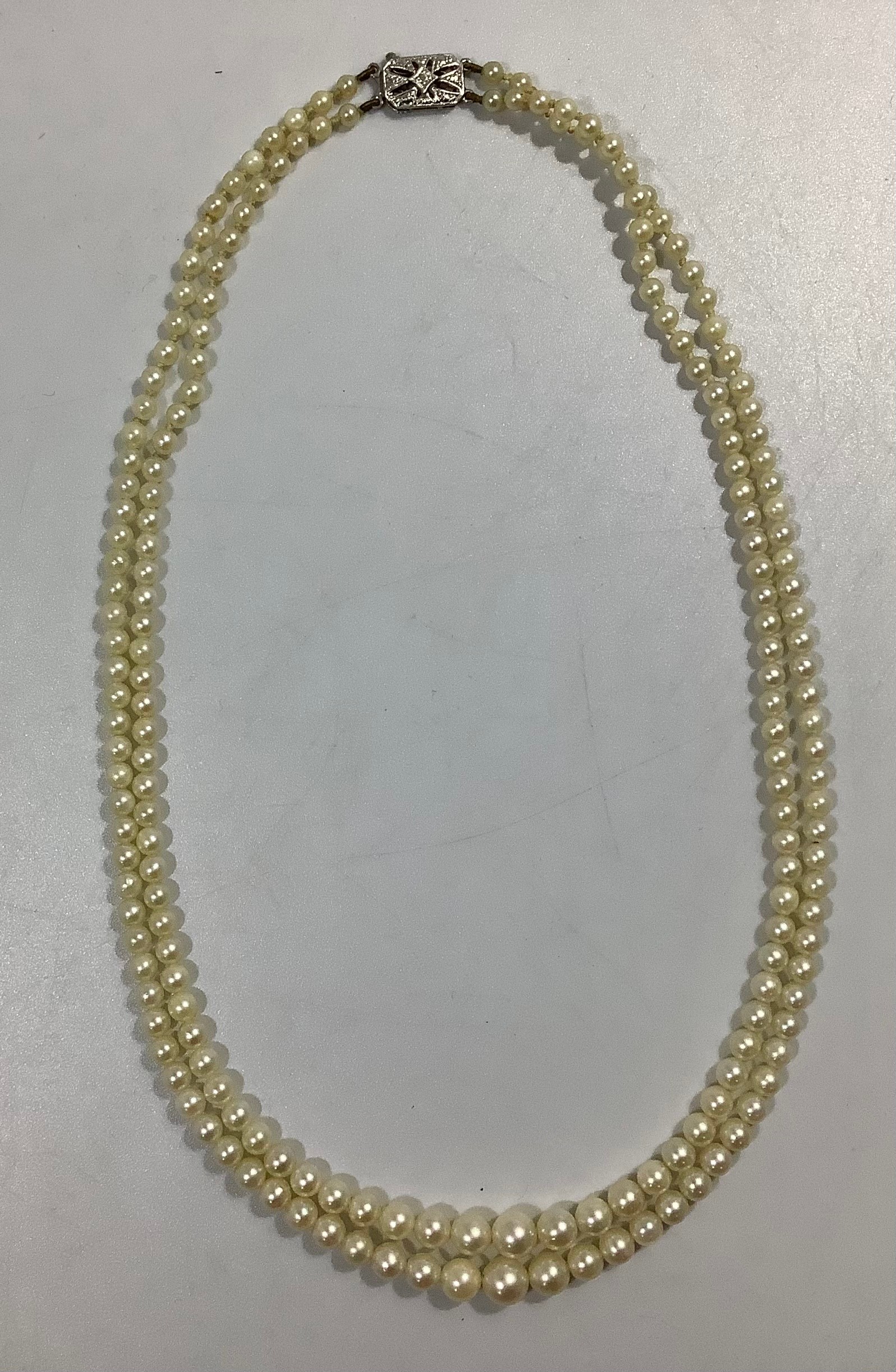 A double-string graduated cultured pearl choker necklace, with 9ct white gold safety clasp, maker