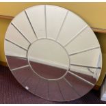 A large modern circular sunburst mirror, with central circular panel surrounding by radiating