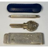 Three items of silver comprising a money clip with oversized hallmarks to one side, a sterling