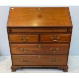 A George III mahogany bureau with fall-front enclosing compartments, pigeon holes and secret